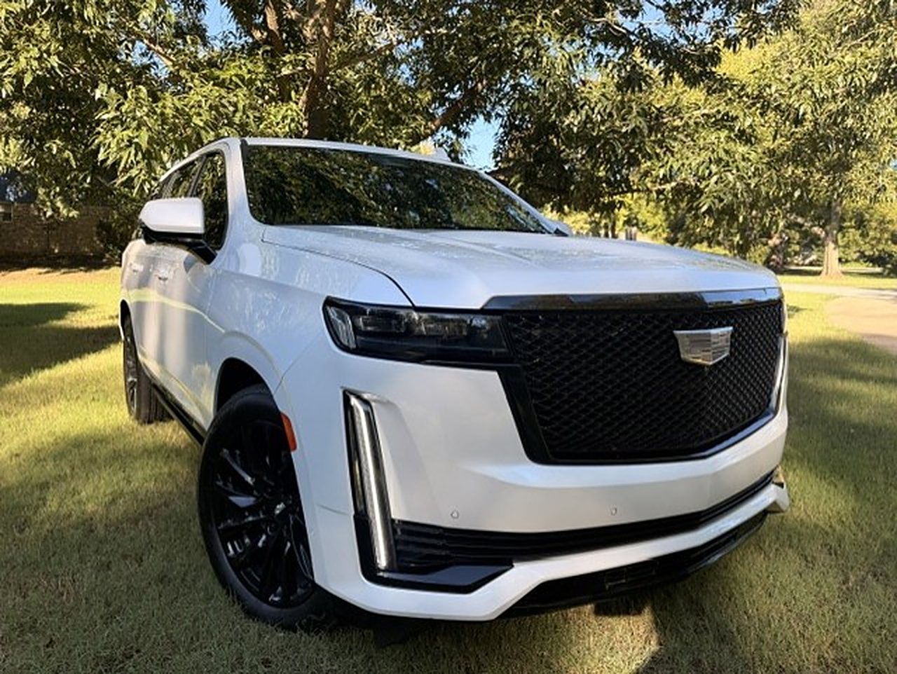 White Cadillac Escalade with black wheels, chauffeured by Social Luxury Sprinter in Tulsa